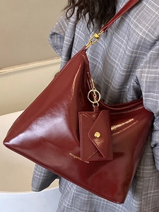 Glossy burgundy leather tote bag with small envelope pouch and gold hardware