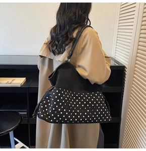 Detail of high-capacity tote bag with black and white polka dots and letter embroidery
