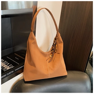 Détail du sac Hobo marron vintage avec pendentif élégant en perles de bois et franges