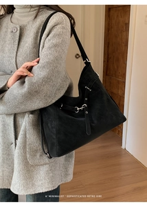 Détail du sac cabas vintage noir avec boucle argentée et manteau en tweed