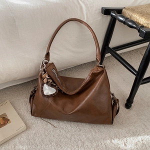 Détail du sac cabas en cuir marron caramel avec pendentif cœur léopard élégant