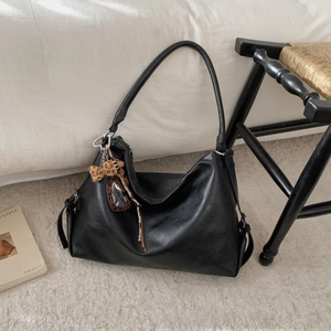 Détail du grand sac cabas en similicuir noir avec pendentif ours léopard et logo