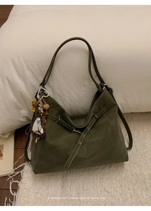 Détail du cabas vert foncé avec texture cuir mat et breloque chic en forme de cœur