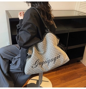 Detail view of the gray starry tote bag with Gugugugii script on a casual shoulder strap