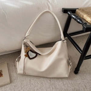 Gros plan sur un sac cabas en similicuir blanc cassé avec un miroir cœur motif léopard