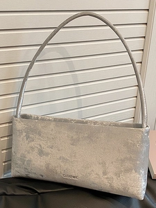 Minimalist silver rectangular underarm bag with metallic texture and thin strap