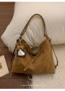 Détail du sac cabas vintage caramel avec texture en cuir et breloque léopard en cœur