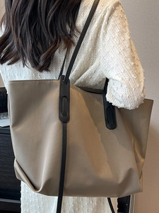 Grand sac cabas kaki minimaliste avec bandoulières noires porté pour le travail