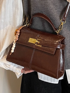 Vintage dark brown faux leather handbag with gold hardware and decorative bead strap