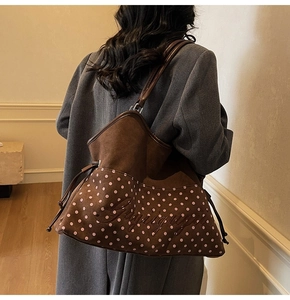 Detail of brown faux suede tote bag featuring pink polka dots and custom embroidery