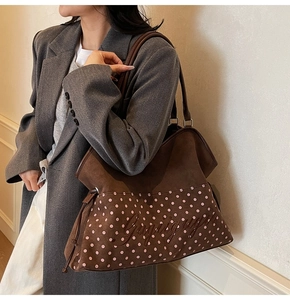 Detail view of suede tote with pink polka dots and Gigigugu embroidery on the side