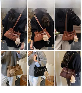 Λεπτομερής όψη από σουέτ τσάντες με αγκράφα ζώνης και μενταγιόν αρκουδάκι σε χρώματα