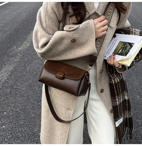Detail of dark brown leather crossbody bag with ethnic patterned wide strap and flap
