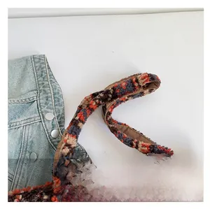 Détail de la poignée en peluche douce sur un sac fourre-tout en polaire à blocs de couleur