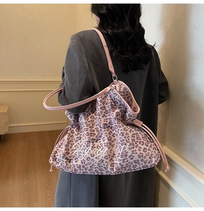 Pink leopard print tote bag with artistic lettering and drawstring closure detail