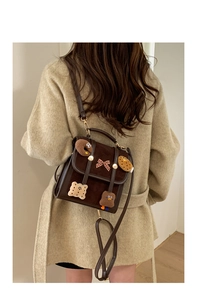 Detail view of coffee suede vintage backpack with cute cartoon patches and bow decoration
