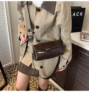Detail of vintage brown patent leather shoulder bag with colorful jacquard wide strap