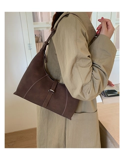 Detail of dark brown matte leather hobo bag featuring contrast white stitching and silver buckle