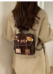 Detail of dark brown mini backpack with cartoon food patches worn on beige coat