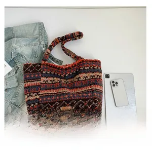 Détail d'un grand sac cabas en peluche avec motifs géométriques et étiquette en cuir brun