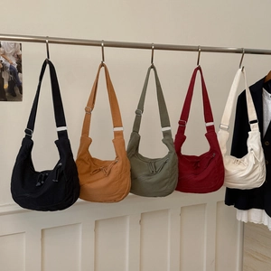Detail view of large canvas crescent crossbody bags in five colors with adjustable straps