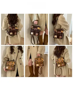 Detail view of a vintage brown mini backpack with bear charms and plaid bow details