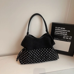Detail of elegant black and white polka dot tote bag with artistic font embroidery
