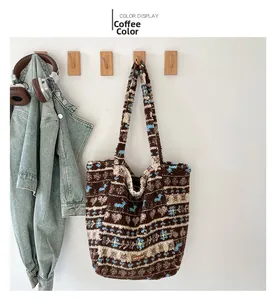Détail du sac cabas en peluche marron café avec motifs floraux bleu clair sur un crochet