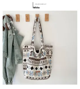 Détail du sac fourre-tout en peluche aux motifs ethniques et étiquette logo en cuir marron
