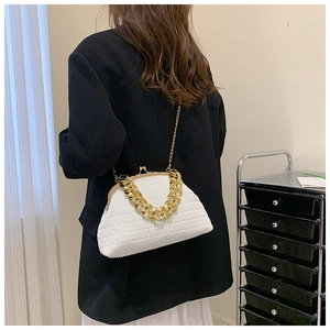 Detail of white pleated cloud bag with metallic chain and retro clasp closure on a model