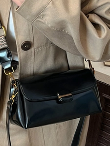 Minimalist black patent leather crossbody bag with vintage gold buckle and woven strap