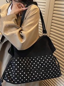 Large black tote bag with white polka dots and Lucky embroidery carried by a model