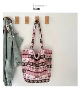 Détail du cabas en peluche rayé rose avec motifs de cœurs et logo en cuir