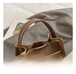 Dettaglio della borsa a secchiello in pelle marrone con fibbia in metallo argento