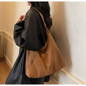 Side view of a large brown suede hobo tote bag shown on model for daily commuting