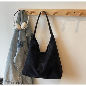 Detail of minimalist black tote bag side stitching and premium matte suede texture