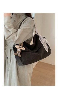 Detail of dark brown suede tote bag with floral scarf and cute plush ginger man charm