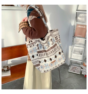 Détail d'un sac cabas en peluche avec motifs floraux géométriques porté à l'épaule