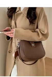 Detail view of a vintage dark brown leather saddle bag with a silver metal clasp