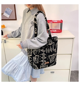 Mannequin portant un sac cabas en peluche avec motif jacquard ethnique noir et blanc