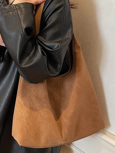 Brown suede tote bag for women showing a large capacity shoulder design on model
