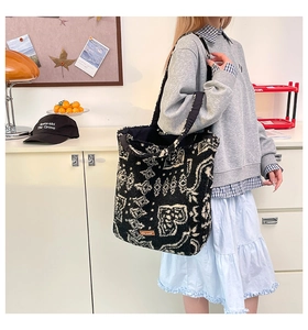 Gros plan d'un sac cabas en peluche avec motifs paisley noir et blanc et texture douce
