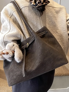 Deep brown matte leather tote bag with white stitching and plush rabbit charm
