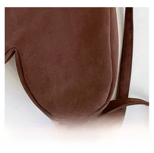Gros plan sur la texture en daim marron foncé d'un sac à bandoulière vintage raffiné