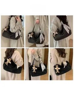 Detail view of large black canvas tote with rabbit charm and floral scarf accent
