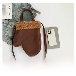 Détail du sac à bandoulière en forme de moufle marron avec garniture en fausse fourrure