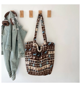 Vue détaillée du sac cabas en peluche avec motifs floraux sur un crochet en bois