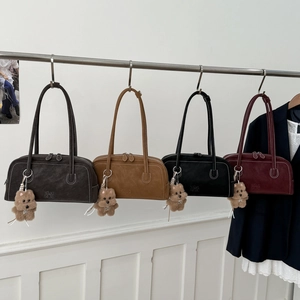 Detailed view of four retro leather bowling bags with white stitching and plush dog charms
