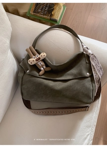 Detail of olive green hobo bag with geometric strap and decorative bunny charm
