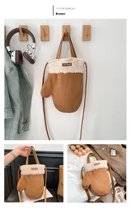 Détail du sac moufles en daim marron avec bordure en peau de mouton et bandoulière